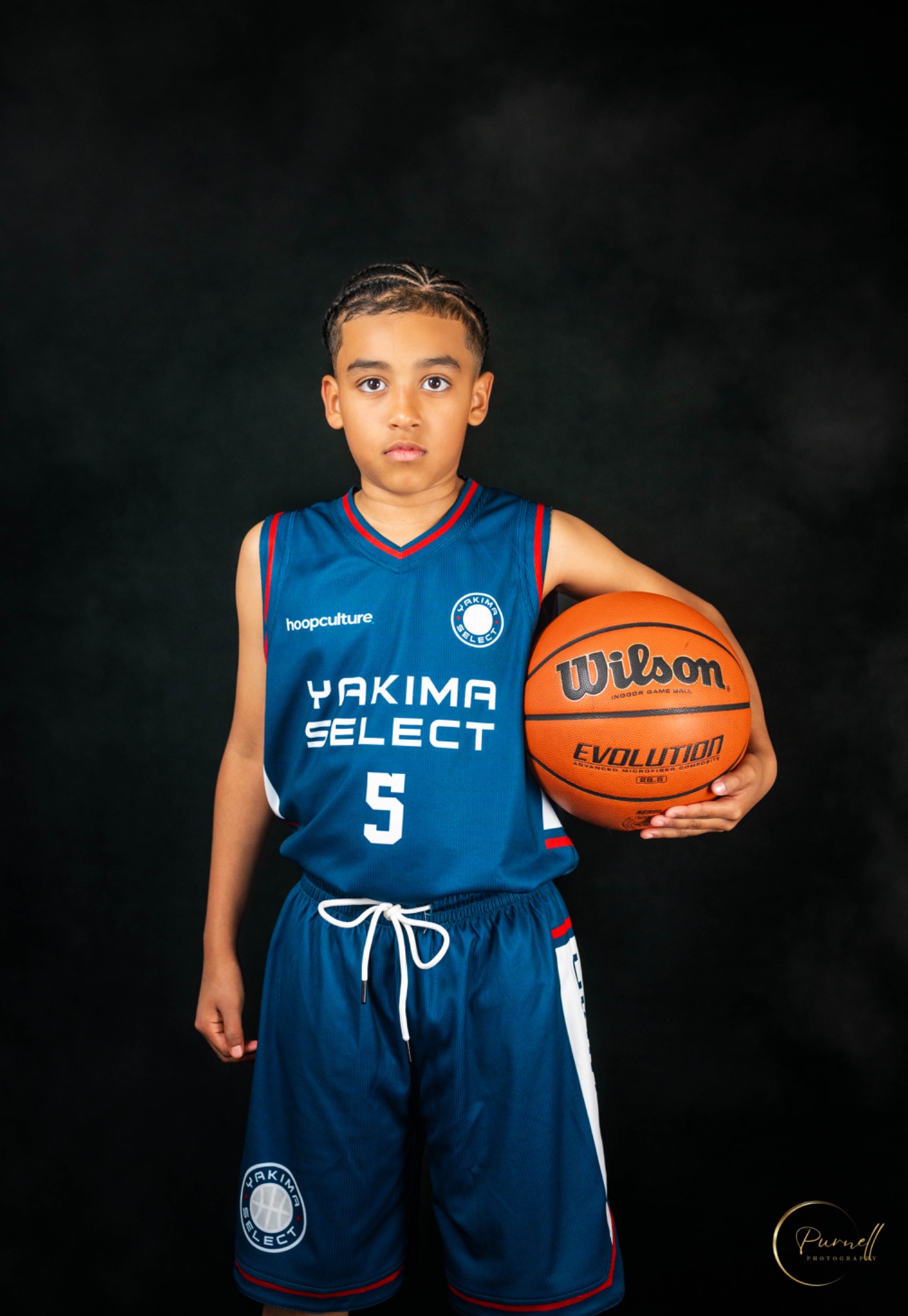 Yakima Select basketball player in a blue uniform holding a Wilson basketball