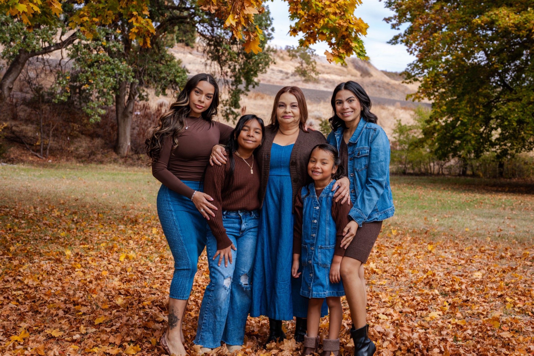 Family portrait surrounded by golden autumn leaves
