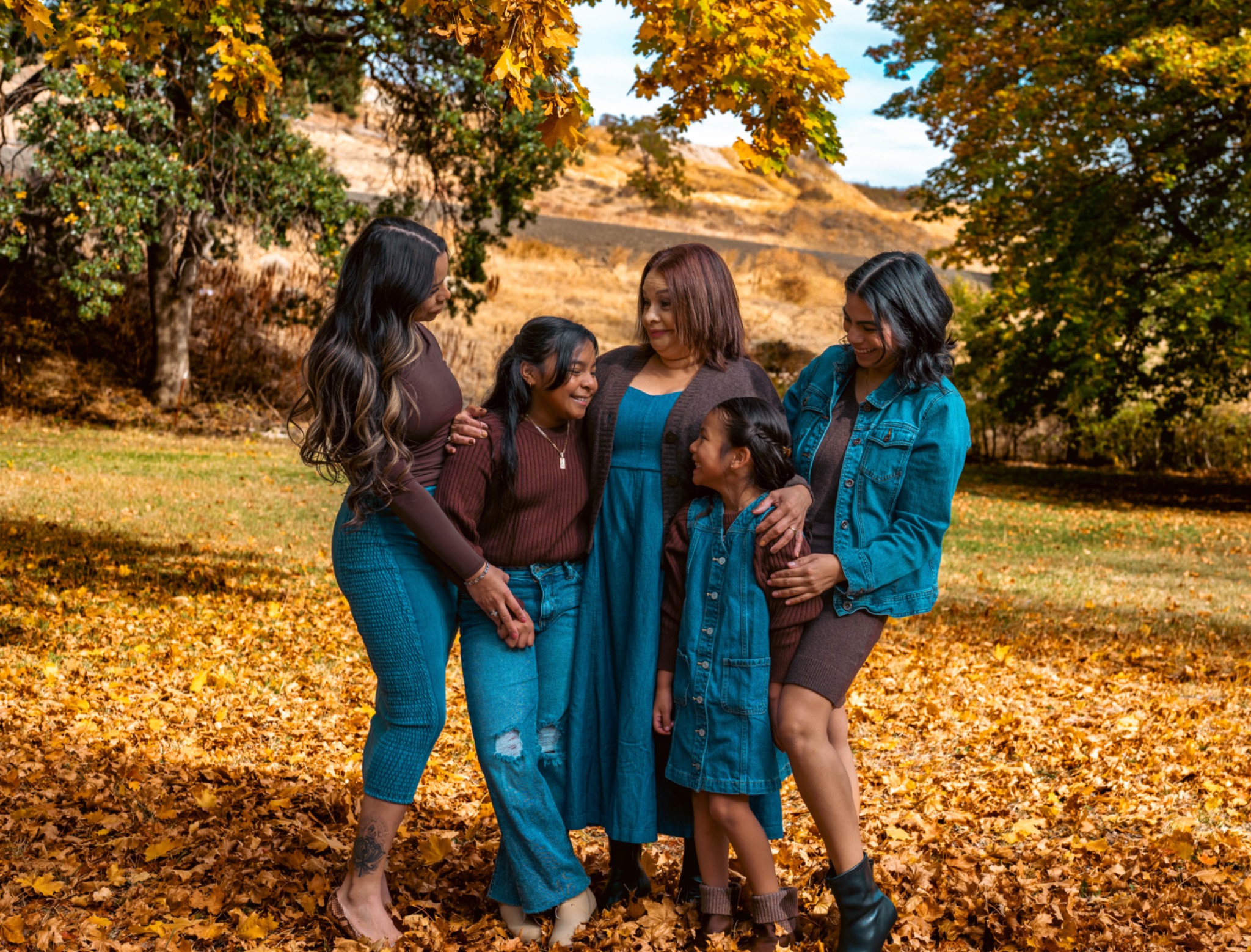 Family sharing a candid moment together under autumn trees